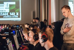 Opettaja neuvoo taka-alalla nuoria esports opiskelijoita.