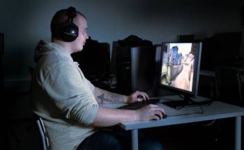 Joonas Leväniemi pelaa kuulokkeet päässä tietokoneella eSports-peliä.