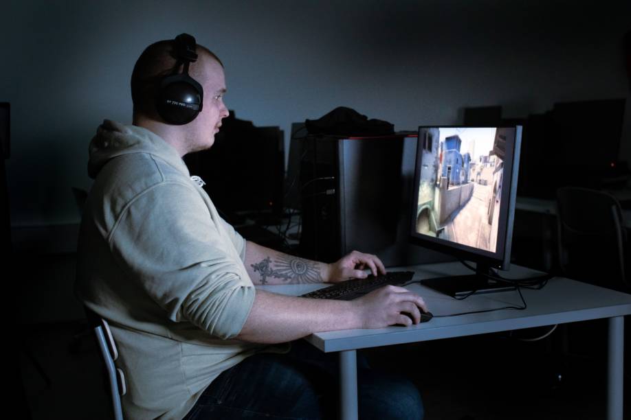 Joonas Leväniemi pelaa kuulokkeet päässä tietokoneella eSports-peliä.