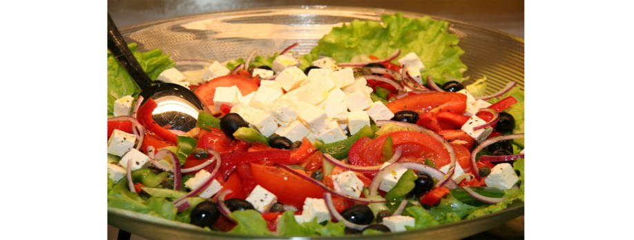 Fetaa, oliiveja, tomaattia, sipulia ja salaattia kulhossa.