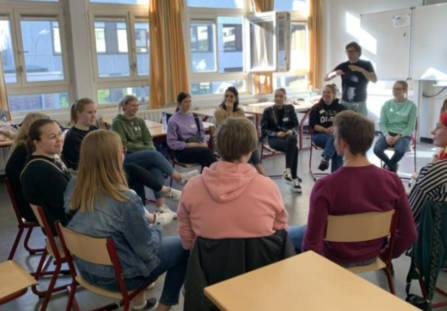 Kuva Antwerpenin koulusta, jossa opiskelijaryhmä tekee ryhmätyötä.