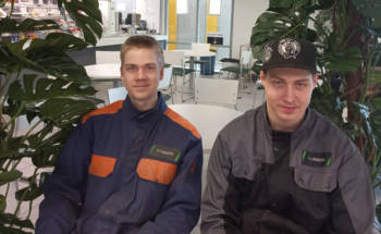 Nuoret kone- ja tuotantotekniikan opiskelijat työvaatteissa istumassa aulassa. putti ja Oliver Koivunen rajattu