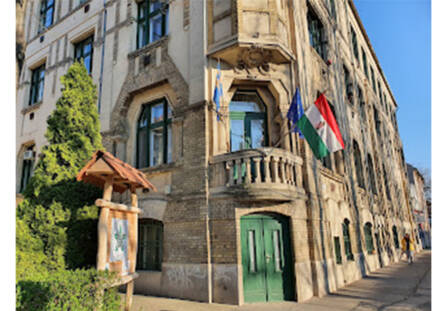 Kuvassa unkarilainen rakennus, jonka vihreän oven yläpuolella Unkarin lippu