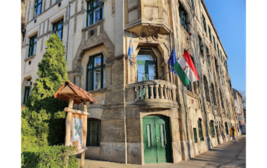 Kuvassa unkarilainen rakennus, jonka vihreän oven yläpuolella Unkarin lippu