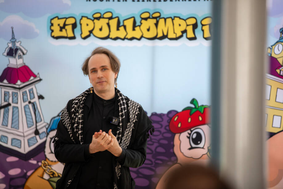 Lauri-Matti Parppei pitämässä puhettaan kisaseinän edessä.