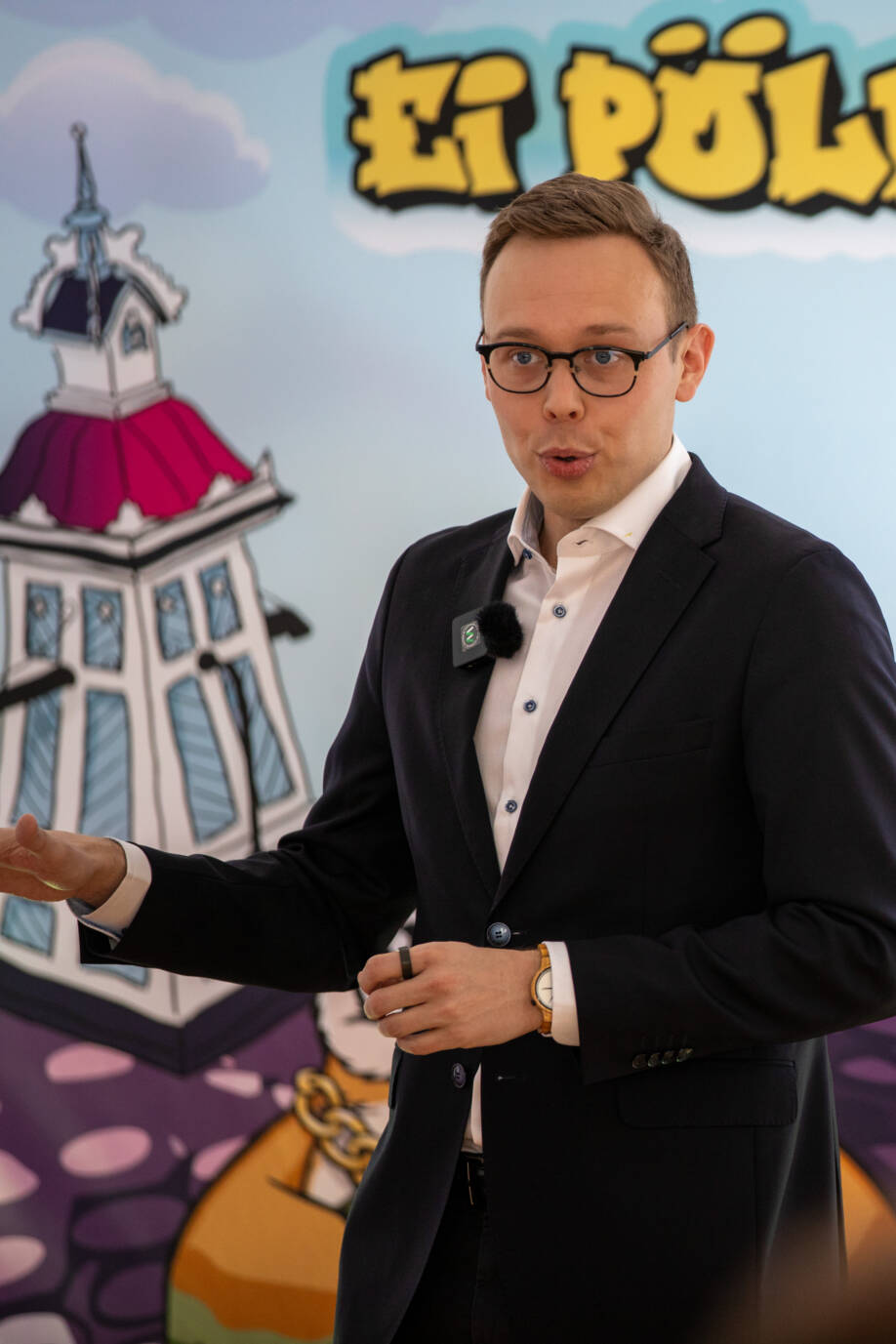 Työministeri pitää avauspuhettaan kisaseinän edessä.