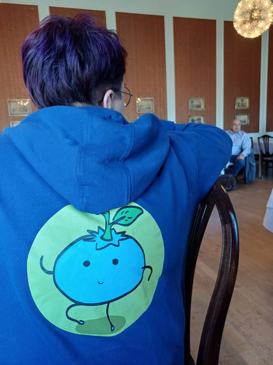 Tapahtumaan osallistuja selin yllään Notkea-hankkeen huppari. Hupparin selässä hankkeen logo.