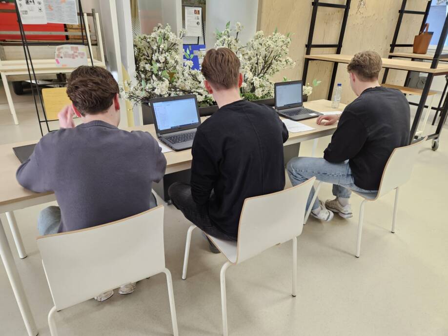 Three students are testing the AI-chatbot.