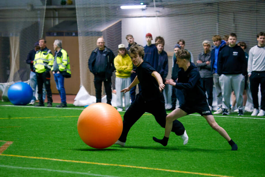Pelaajat juoksevat norsufutispelissä ison pallon perässä.