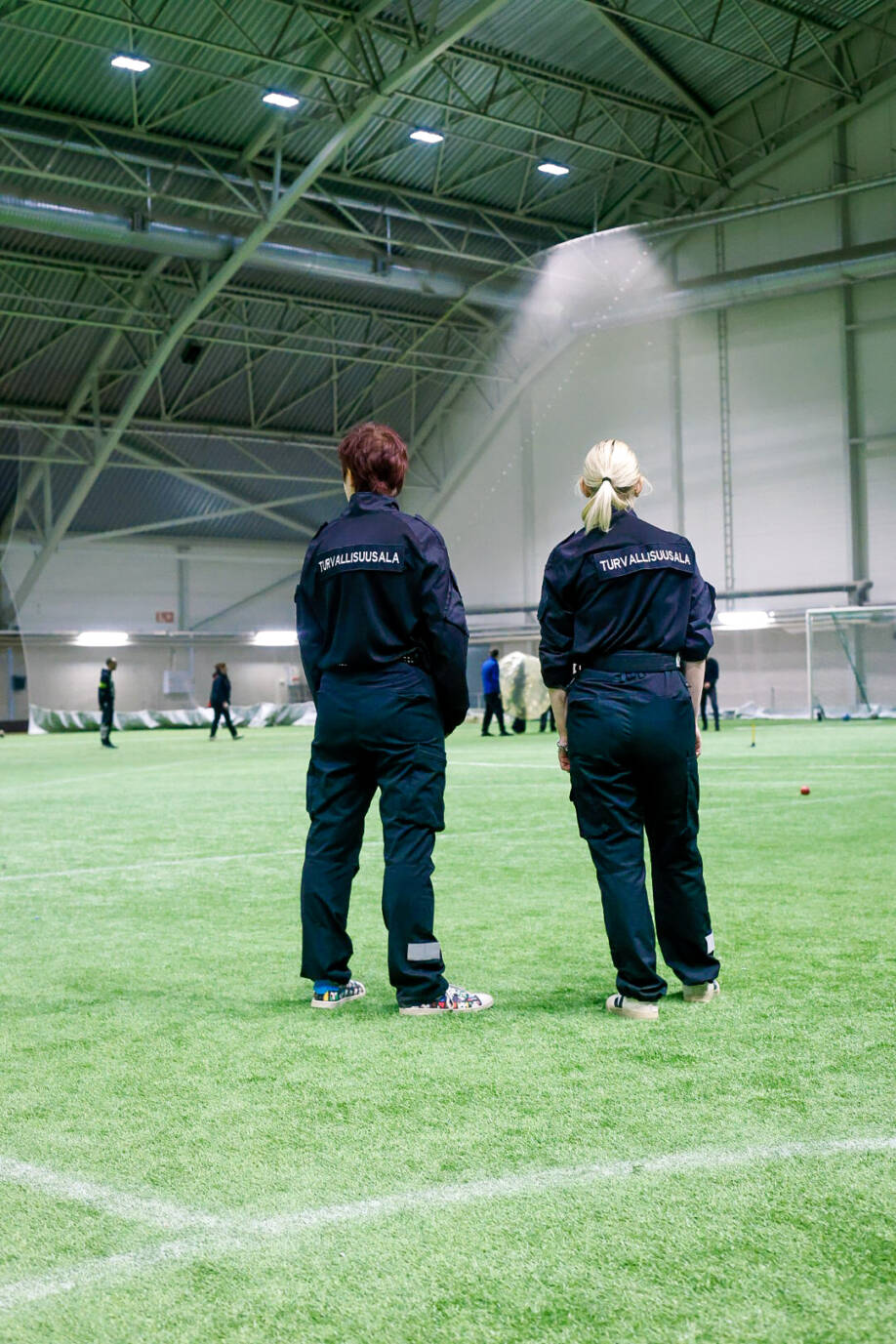 Turvallisuusalan opiskelijat valvomassa tapahtuman turvallisuutta pelikentällä.