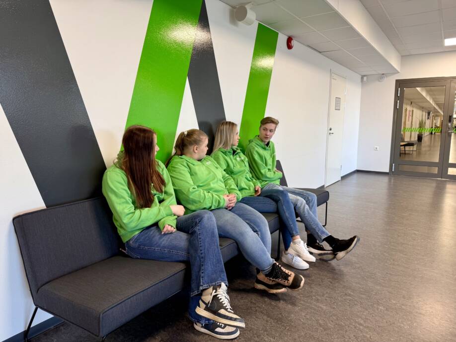 WinNovan opiskelijoita istuu sohvalla käytävällä.