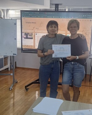 Kaksi koulutuksen suorittanut yhteiskuvassa diplomi kädessä.