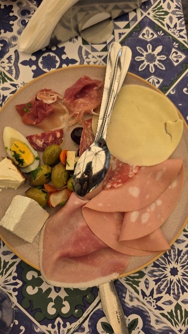 Ruoka-annoksessa on muun muassa kinkkua, oliiveja ja erilaisia juustoja.