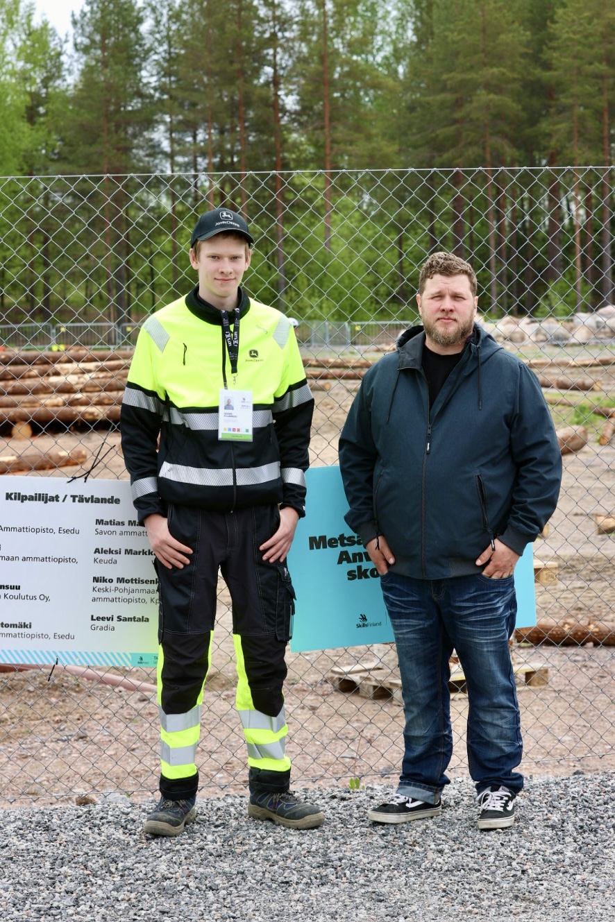 Metsäkoneen käyttö lajin kilpailija Severi ja valmentaja Matti Vormisto.