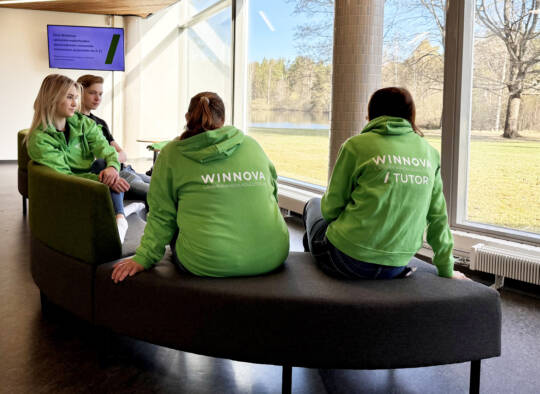 opiskelijat istumassa sohvalla, yhdellä tutor-huppari.