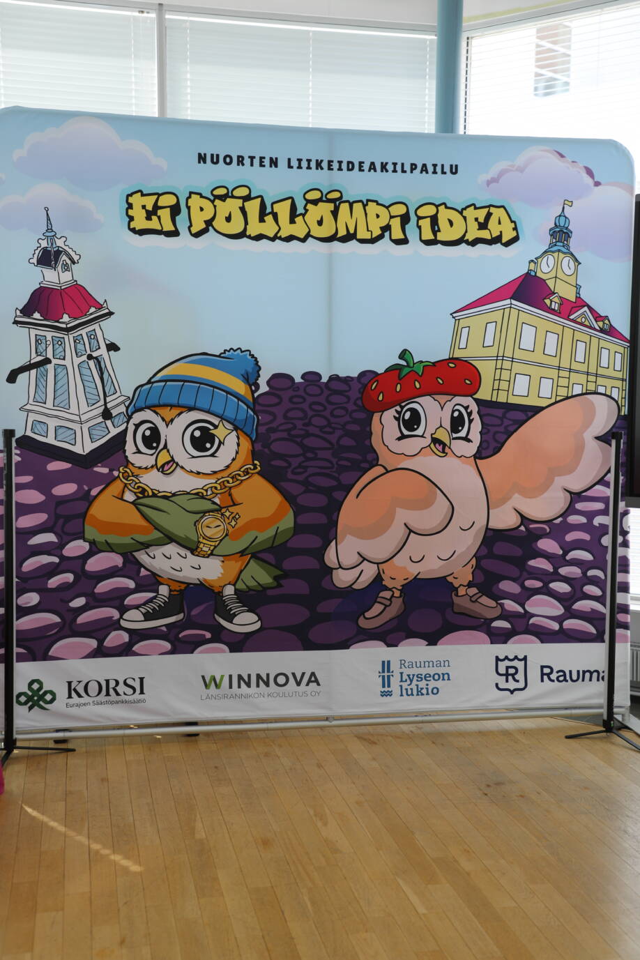 Pöllömpi idea -seinämässä piirrettynä Rauman nähtävyyksiä ja kaksi pöllöä.