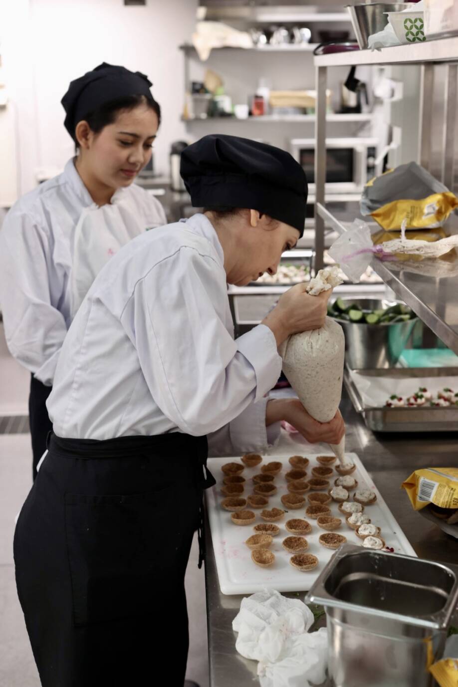 Ravintola- ja catering-alan opiskelijat työskentelee keittiössä valmistamassa ruokia.