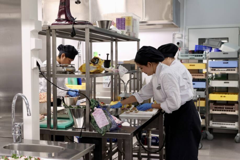Ravintola- ja catering-alan opiskelijat työskentelee keittiössä valmistamassa ruokia.